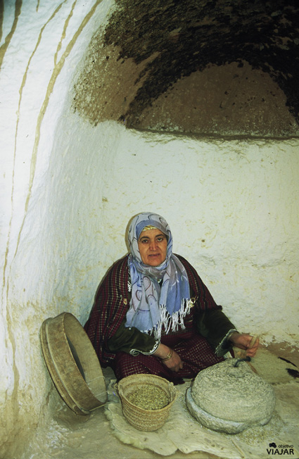 Mujer moliendo trigo en una casa troglodita de Matmata. Túnez